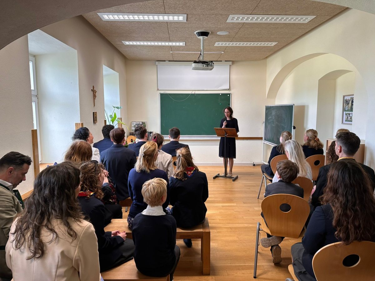 Ansprache am Rednerpult vor Schülerinnen, Schülern, Eltern und Lehrkräften